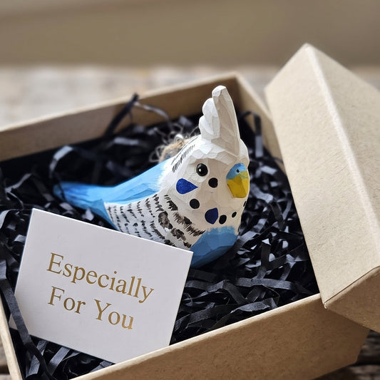 Hand-carved blue and white wooden budgie ornament packaged in a natural gift box