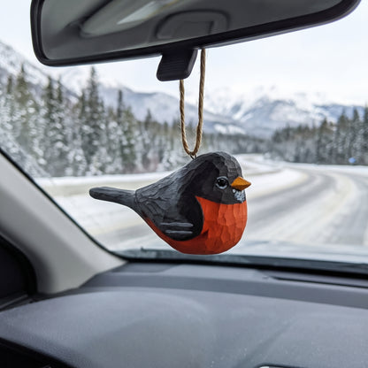 Hand-carved wooden American Robin ornament hanging from a car rearview mirror.