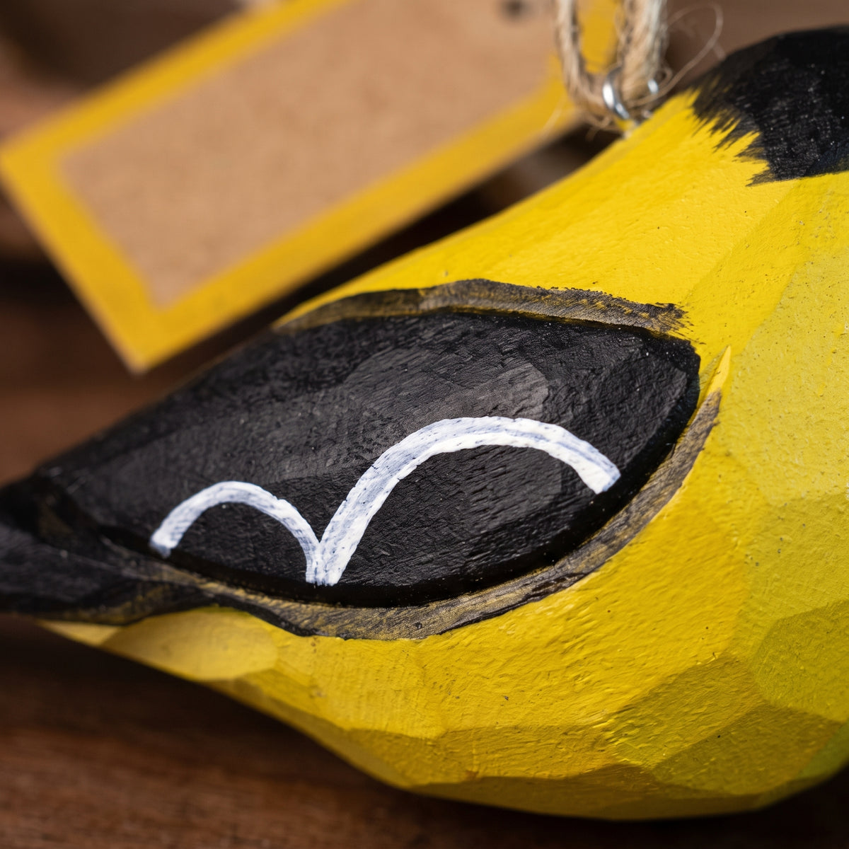 Close-up detail of hand-painted wooden American Goldfinch ornament