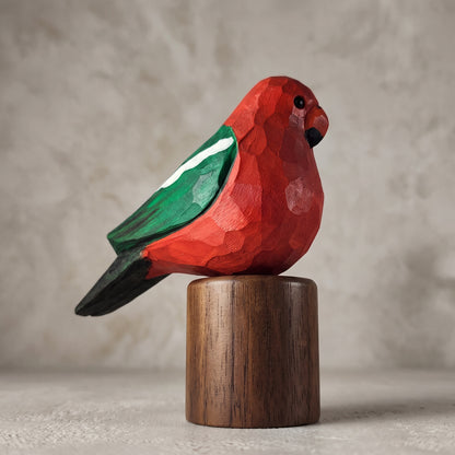Side profile of a hand-carved wooden Australian King Parrot figurine with a vibrant red body, green wing, and black tail, mounted on a solid Black Walnut cylinder base.
