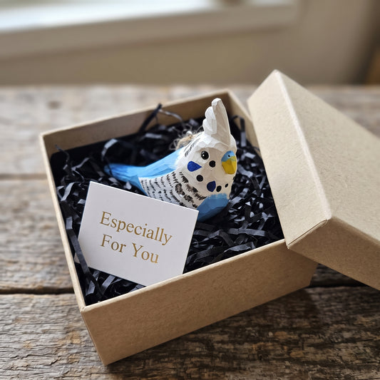 Hand-carved blue and white wooden budgie ornament packaged in a natural gift box
