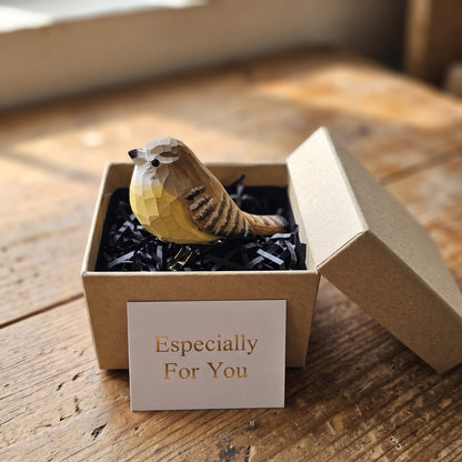 Hand-carved wooden Carolina Wren bird ornament perched inside an open kraft gift box filled with black shredded paper, accompanied by a gift card reading 'Especially For You' in gold text.