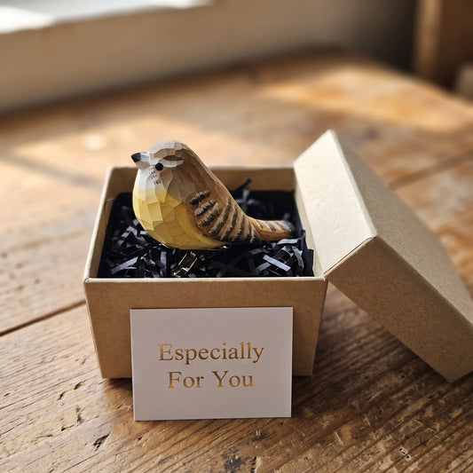 Hand-carved wooden Carolina Wren bird ornament perched inside an open kraft gift box filled with black shredded paper, accompanied by a gift card reading 'Especially For You' in gold text.