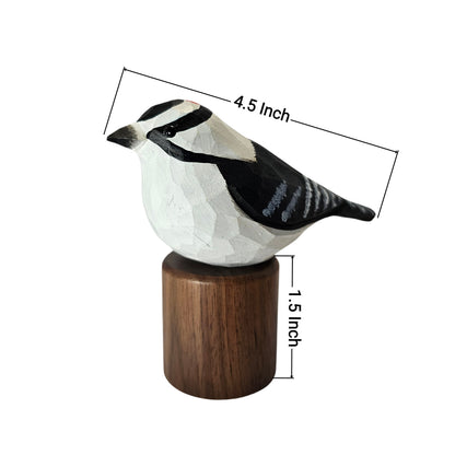 A carved wooden Downy Woodpecker figurine with a dark brown cylindrical base, shown on a white background with dimension lines indicating 4.5 inch length and 1.