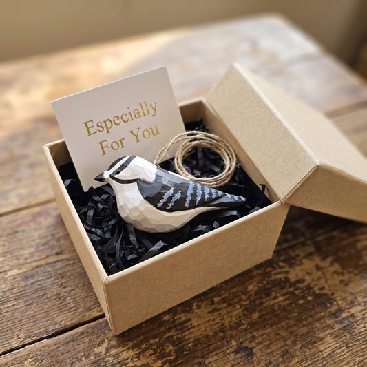Hand-carved Downy Woodpecker wooden ornament presented inside a craft gift box with black shredded paper filler and an "Especially For You" card.