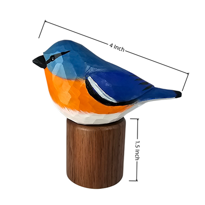 A painted Eastern Bluebird figurine perched on a small wooden base, shown on a white background with dimension lines indicating 4 inch length and 1.5 inch height.