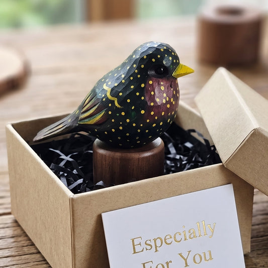 Hand-carved wooden European Starling figurine in a kraft gift box with an Especially For You card on a wooden table