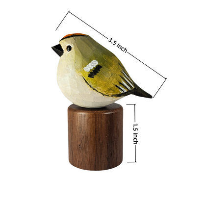 A small painted Golden-crowned kinglet figurine perched on a round wooden base, shown on a white background with dimension lines indicating 3.5 inch length and 1.