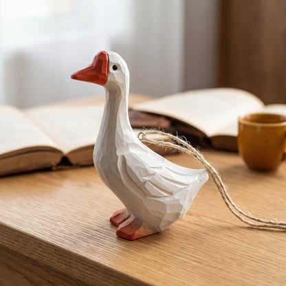 Hand-carved white goose wooden hanging ornament standing on a wooden surface