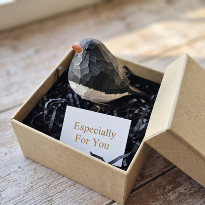 Hand-carved wooden Dark-Eyed Junco clip-on ornament packaged inside a kraft gift box with black shredded paper and an "Especially For You" card.