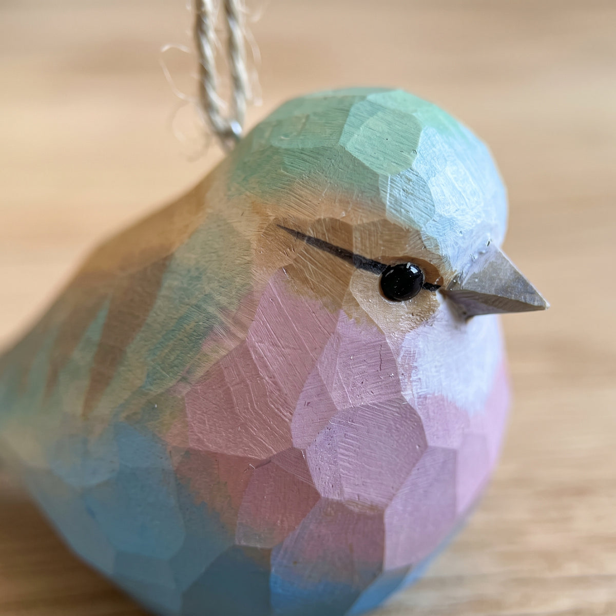 Macro close-up of hand-carved basswood Lilac-Breasted Roller ornament showing carved wood texture and hand-painted plumage