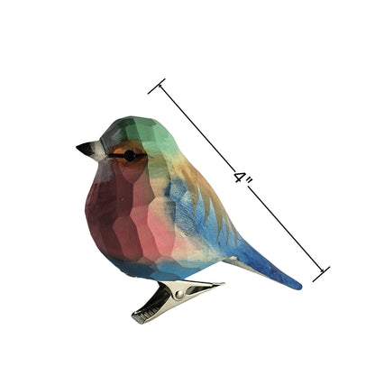 Side profile view of a hand-carved, hand-painted wooden Lilac-Breasted Roller bird clip-on ornament mounted on a metal spring clip against a plain white background, with a dimension line indicating a length of 4 inches.