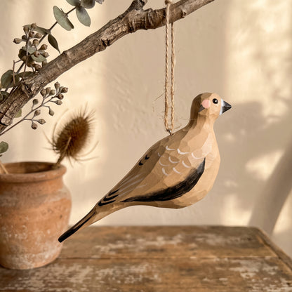 Hand-painted wooden Mourning Dove bird ornament suspended from a rustic branch