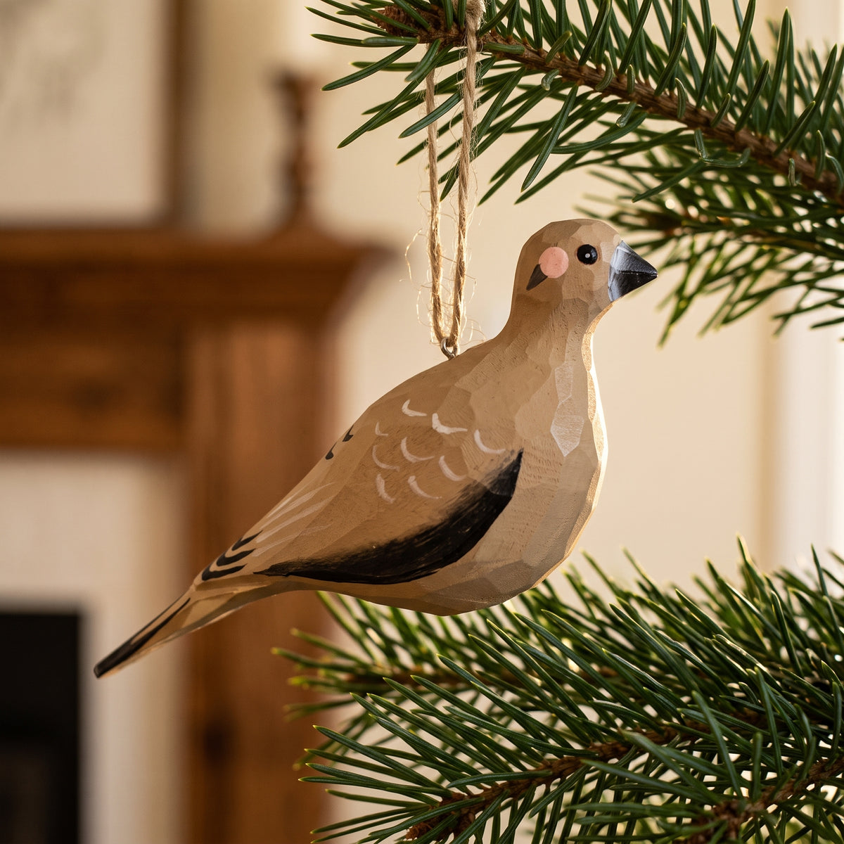 Hand-carved wooden Mourning Dove ornament hanging on a pine branch