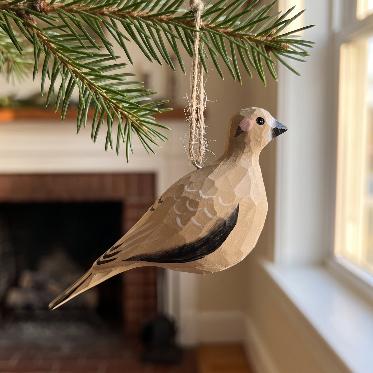 Hand-painted wooden Mourning Dove bird ornament suspended from an evergreen branch