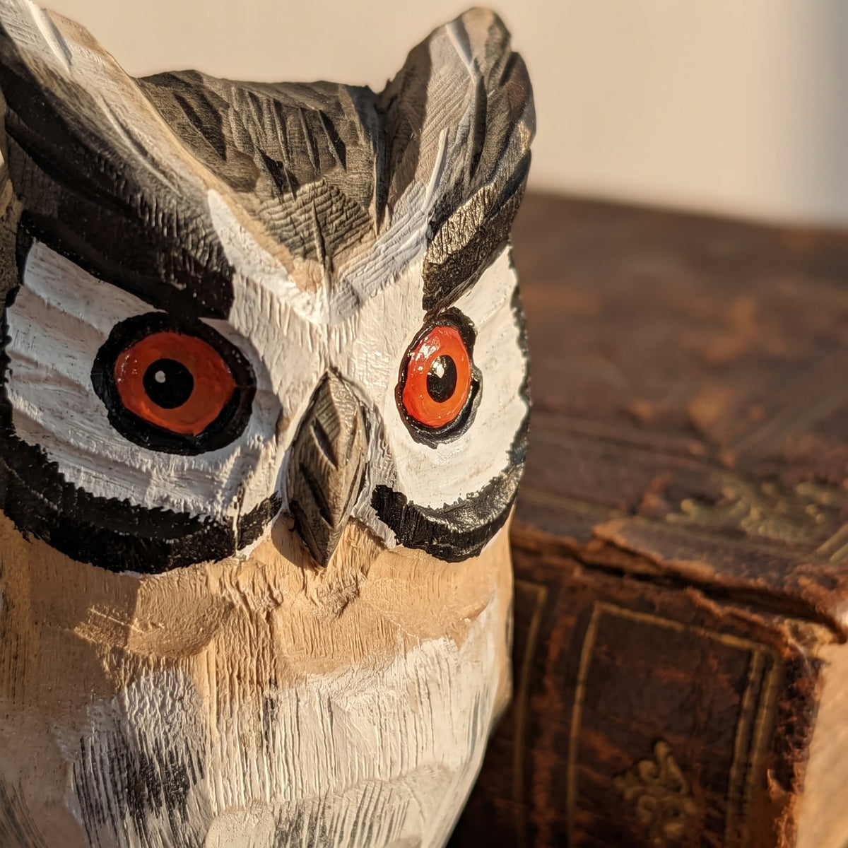 Side detail of hand-carved feather textures on wooden owl figurine