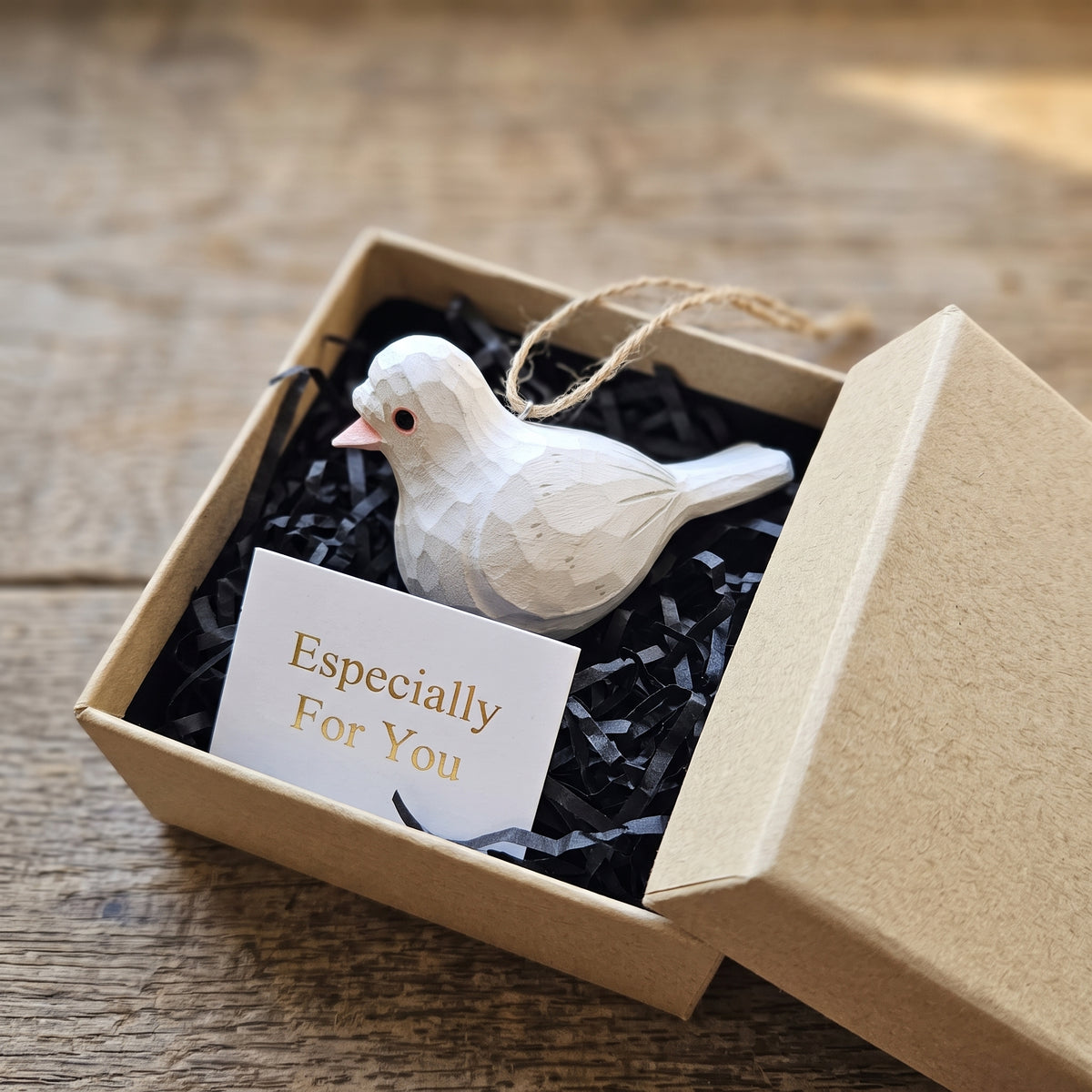 Hand-carved white wooden baby pigeon ornament packaged in a gift box with an "Especially For You" card.