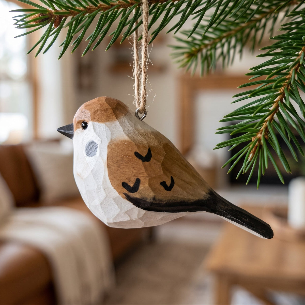 Hand-carved basswood sparrow hanging ornament displayed on a pine branch