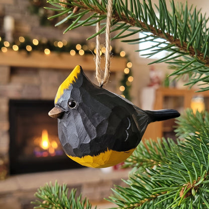 Hand-carved wooden Sultan Tit bird ornament with yellow crest hanging on a pine tree branch
