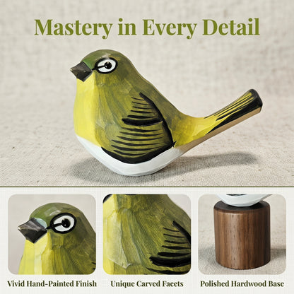 A hand-painted wooden White-eyes figurine displayed on a light beige textured fabric background, with the headline 'Mastery in Every Detail' above. The main bird is olive green and yellow with black and white painted details.