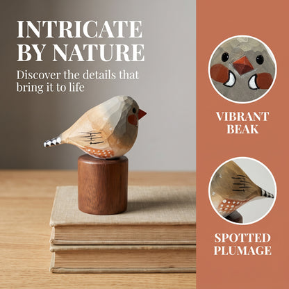 A wooden Zebra Finch figurine with a carved beak and spotted plumage details, displayed on a stack of books. The left side features the text 'INTRICATE BY NATURE' and 'Discover the details that bring it to life', while the right side has a rust-colored panel with two circular close-ups labeled 'VIBRANT BEAK' and 'SPOTTED PLUMAGE'.